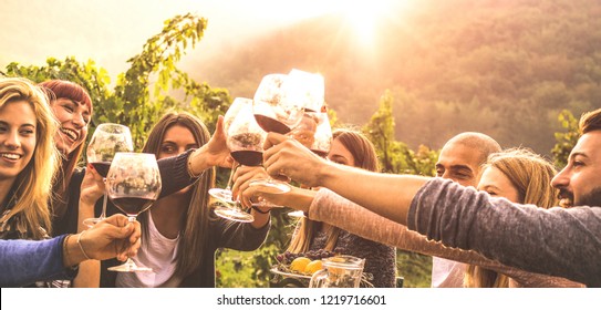 Young Friends Having Fun Outdoor - Happy People Enjoying Harvest Time Together At Farm House Winery Countryside - Youth Friendship Concept - Hand Toasting Red Wine At Pic Nic In Vineyard Before Sunset