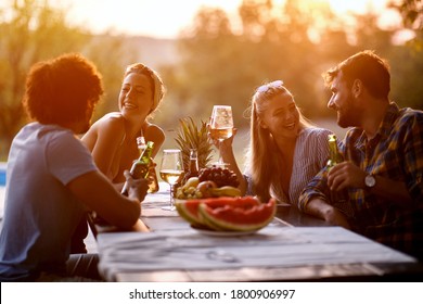 Young friends having fun outdoor, talking and laughing enjoying at evening. - Powered by Shutterstock