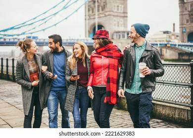 Young friends having fun outdoor at the city with Tower Bridge in London in background - Focus on right man face - Powered by Shutterstock