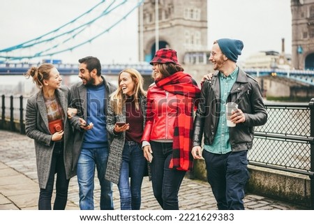 Young friends having fun outdoor at the city with Tower Bridge in London in background - Focus on right man face