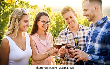 Young friends having fun outdoors - Happy people enjoying harvest time together at farmhouse winery countryside - Tasting red wine at vineyard - Focus on the girl's face with glasses - Powered by Shutterstock