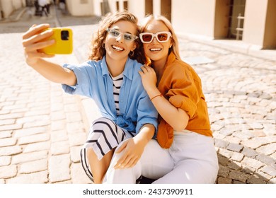 Young friends having fun and take selfie on the phone together. Lifestyle, leisure, entertainment, youth concept. - Powered by Shutterstock