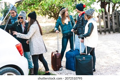 Young friends having fun together packing back from winter time vacation - Friendship hangout reunion concept with happy people wearing fashion clothes traveling on the road - Bright contrast filter