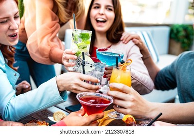 Young friends holding multicolored drinks - Trendy people having fun together drinking cocktails at happy hour - Social gathering and life style concept on vivid filter with shallow depth of field - Powered by Shutterstock