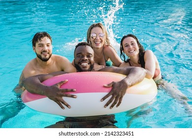 Young friends inside swimming pool having fun during summer vacations - Focus on African man - Powered by Shutterstock