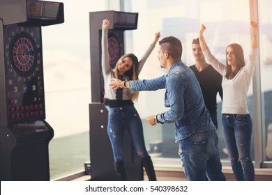 Young Friends Playing Darts In A Club