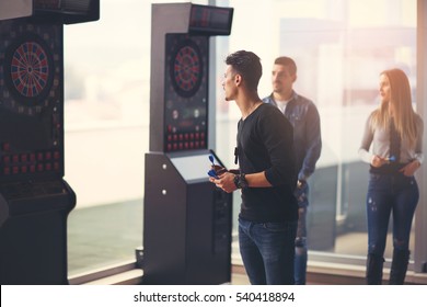 Young Friends Playing Darts In A Club