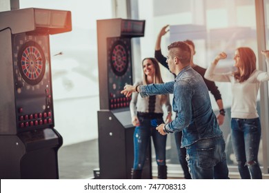 Young Friends Playing Darts In A Club