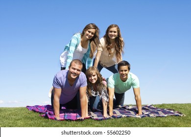 Young Friends Playing Outdoors Making A Human Pyramid