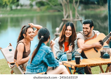 Young friends share a fun summer weekend outdoors with a campfire, bar-b-q, and picnic, celebrating vacation, friendship, and happy moments together. - Powered by Shutterstock