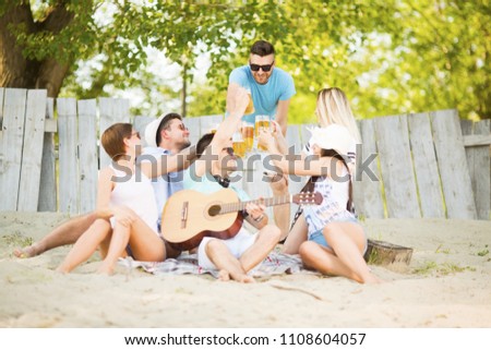 Similar – Young friends holding woman on top of surfboard