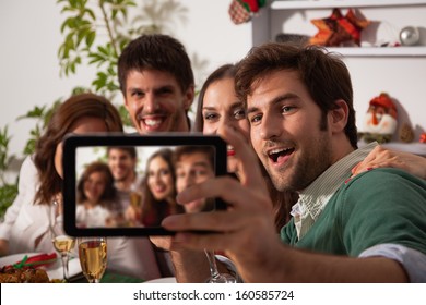 Young friends taking self portrait with digital tablet on Christmas eve.  - Powered by Shutterstock