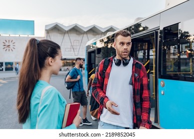 Young friends waiting at a bus stop and talking cheerfully. Tourists in new town. Best friends traveling together in a city. Focus on a caucasian hipster man wearing checkered shirt and headphones. - Powered by Shutterstock