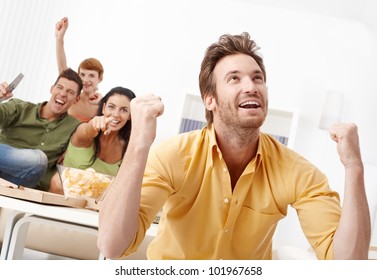 Young Friends Watching Football On Tv At Home