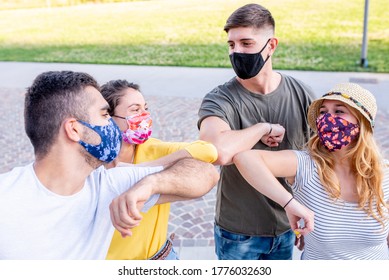 Junge Freunde, die die Schutzmaske tragen, begrüßen sich gegenseitig mit neuen Grüßen, berühren Ellbogen, um die Ausbreitung des Corona-Virus zu verhindern - Körperliche Entfernung und Sicherheitskonzept, neue normale
