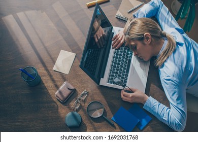 Young frustrated exhausted woman laid her head down on the table sit work at desk with contemporary pc laptop isolated on background. Achievement business career concept. Copy space

