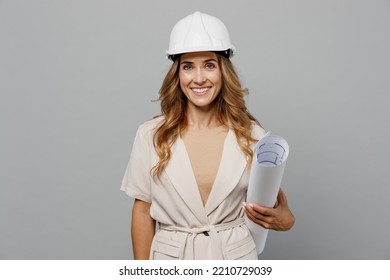 Young fun architect engineer designer employee white woman she wear pastel clothes hardhat hold blueprints isolated on plain light grey background studio portrait. People work on architecture project - Powered by Shutterstock