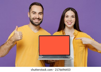 Young Fun Couple Two Friends Family Man Woman Together In Yellow Casual Clothes Hold Use Work Point On Laptop Pc Computer Blank Screen Workspace Area Show Thumb Up Isolated On Plain Violet Background