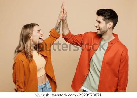 Young fun happy couple two friends family man woman wear casual clothes together meeting together greeting giving high five clapping hands folded isolated on pastel plain light beige color background