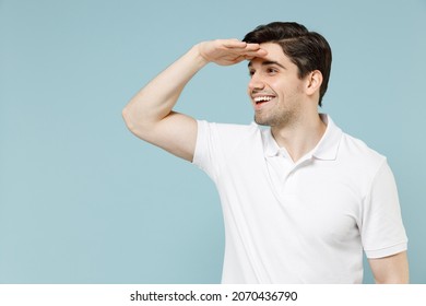 Young fun impressed unshaven cheerful man 20s in white casual basic t-shirt hold hand at forehead look far away distance isolated on pastel blue background studio portrait. People lifestyle concept - Shutterstock ID 2070436790