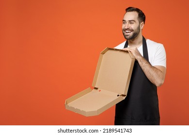 Young Fun Man Barista Bartender Barman Employee In Apron White T-shirt Work Coffee Shop Holding Empty Italian Pizza In Cardboard Flatbox Isolated On Orange Background Small Business Startup Concept