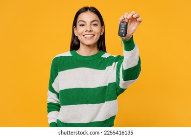 Young fun satisfied happy smiling brunette latin woman wear casual cozy green knitted sweater hold give car keys fob keyless system isolated on plain yellow background studio People lifestyle concept - Powered by Shutterstock