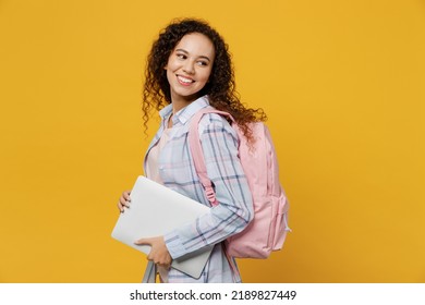 Young Fun Smart Black Teen Girl Student She Wear Casual Clothes Backpack Bag Hold Closed Laptop Pc Computer Look Aside Isolated On Plain Yellow Color Background High School University College Concept