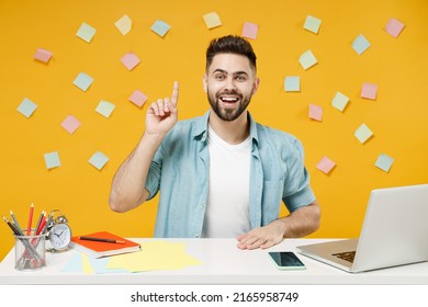 Young Fun Smart Proactive Smiling Employee Business Man In Shirt Sit Work At White Office Desk With Pc Laptop Holding Index Finger Up With Great New Idea Isolated On Yellow Background Studio Portrait.