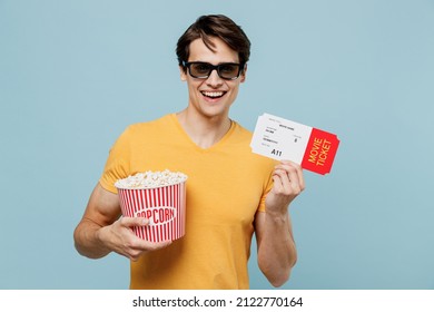 Young Fun Smiling Happy Cheerful Man In 3d Glasses Watch Movie Film Hold Bucket Of Popcorn Ticket Isolated On Plain Pastel Light Blue Background Studio. People Emotions In Cinema Lifestyle Concept.