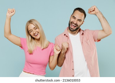 Young fun smiling happy couple two friends family man woman in casual clothes dancing rejoicing together isolated on pastel plain light blue color background studio portrait People lifestyle concept