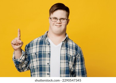 Young fun smiling man with down syndrome wearing glasses casual clothes holding index finger up with great new idea isolated on pastel plain yellow color background. Genetic disease world day concept - Powered by Shutterstock