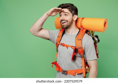 Young fun traveler white man carry backpack stuff mat look far away distance isolated on plain green background. Tourist leads active lifestyle walk on spare time. Hiking trek rest travel trip concept - Powered by Shutterstock