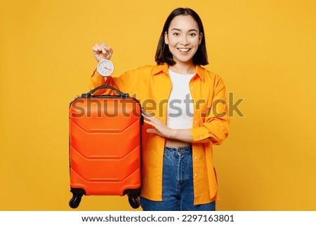 Young fun woman wear summer casual clothes use luggage scales check weight isolated on plain yellow background. Tourist travel abroad in free spare time rest getaway. Air flight trip journey concept