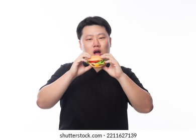 Young Funny Fat Asian Man Eating Hamburger Isolated On White Background, Unhealthy Concept.