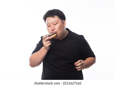 Young Funny Fat Asian Man Eating Chocolate Donuts Isolated On White Background, Unhealthy Concept.