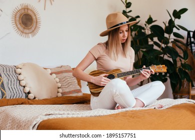 Young Funny Hipster Girl Having Fun And Playing On Small Ukulele Guitar, Singing And Dancing. Wearing A Hat, Joy, Positive Mood. Instagram Live Concert