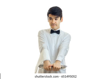 Young Funny Waiter In A White Shirt Holding Before An Empty Tray