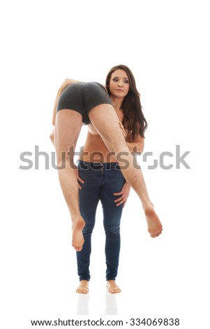 Young funny woman carrying man on her shoulder.