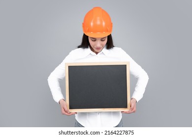 Young Funny Woman Construction Manager. Woman Builder Isolated Portrait With Protect Helmet And Board. Gray Background, Empty Space, Copy Space.