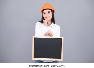 Young Funny Woman Construction Manager. Woman Builder Isolated Portrait With Protect Helmet And Board. Gray Background, Empty Space, Copy Space.