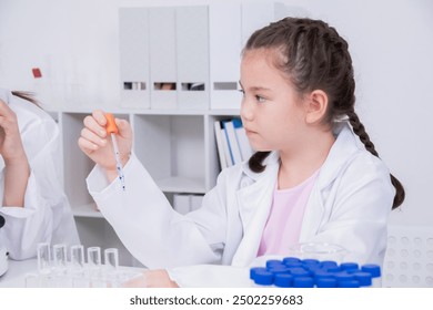 Young future scientist girl in white lab coat holding test tube with blue liquid, thoughtfully, curious, engaging in a science experiment in a laboratory with scientific equipment. education concept - Powered by Shutterstock