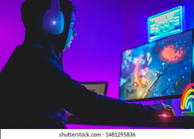 Young gamer playing at strategy online game - Male guy having fun gaming and streaming online - New technology game trends and entertainment concept - Focus on his hand