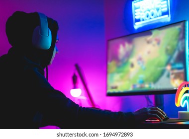 Young gamer playing at strategy online game - Male guy having fun gaming and streaming online - New technology game trends and entertainment concept - Soft focus on his hand - Shutterstock ID 1694972893