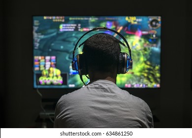 Young gamer playing video game wearing headphone. - Shutterstock ID 634861250