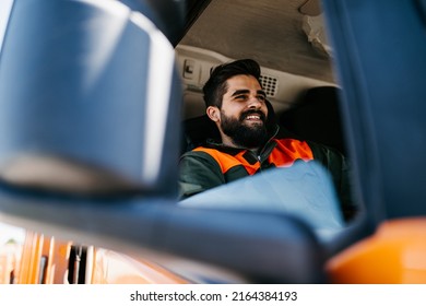 Young Garbage Removal Worker Driving A Waste Truck.