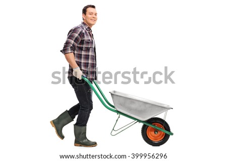 Young gardener pushing a wheelbarrow and looking at the camera isolated on white background
