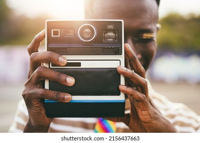 Young gay african man using vintage old camera outdoor - Focus on hands - Powered by Shutterstock