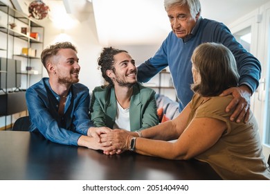 A Young Gay Couple Declares Their Homosexuality To Their Parents By Going Out. The Family Holds Hands And Everyone Smiles.