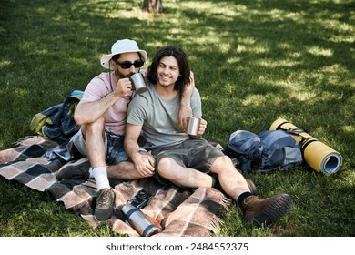 A young gay couple enjoys a break during their summer hike, sharing drinks and laughter in the peaceful wilderness. - Powered by Shutterstock