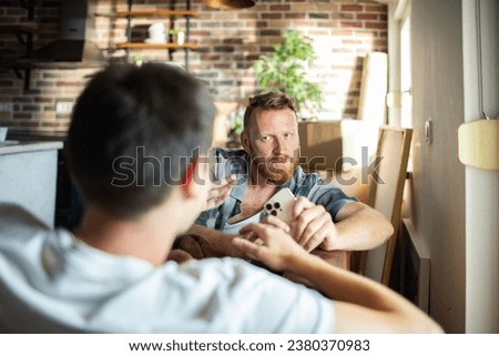 Young gay couple having argument on the couch at home